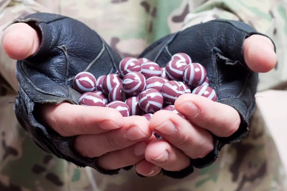 close up of paintball balls in the hand of player
